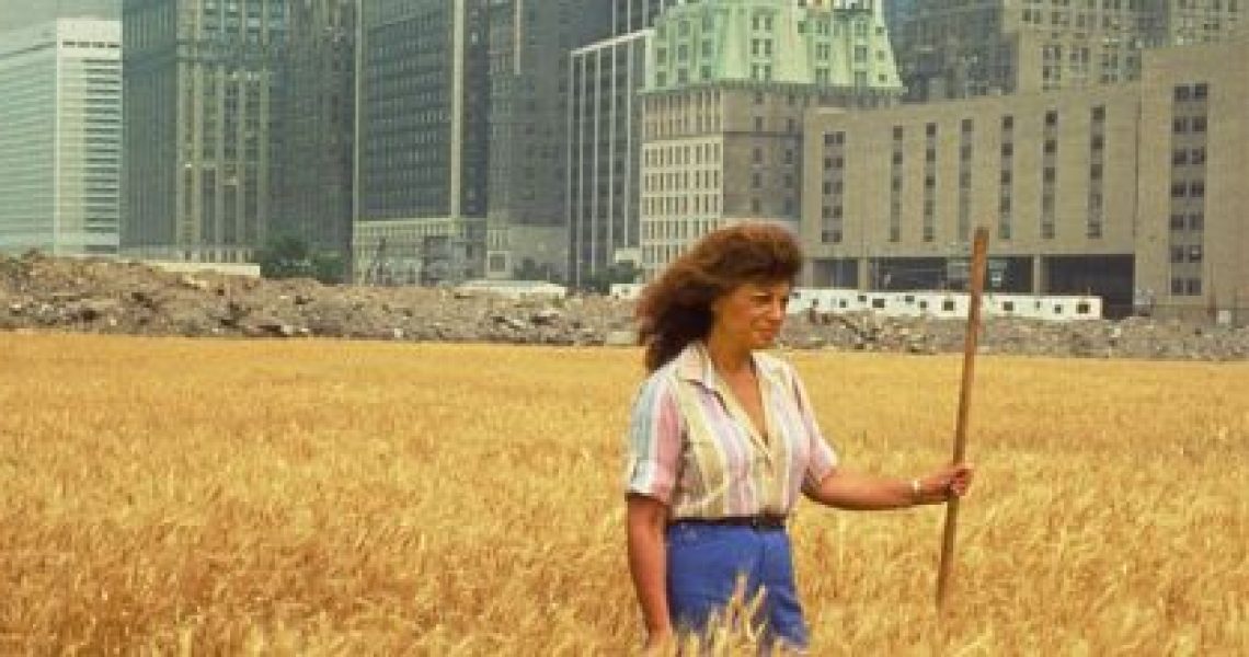 Agnes Denes, Wheatfield—A Confrontation: Battery Park Landfill, Downtown Manhattan, with Agnes Denes Standing in the Field, 1982. Courtesy the artist and Leslie Tonkonow Artworks + Projects, New York. Photo: John McGrall.